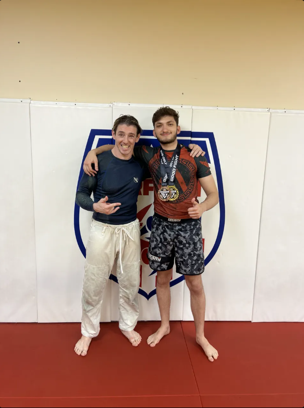 Josh and his coach with medals after a competition win